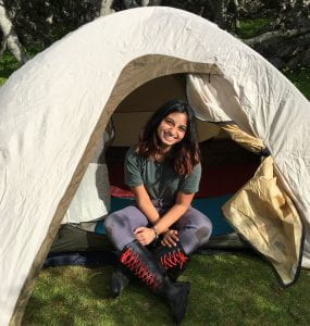 Undergraduate Ishana sitting in a tent.